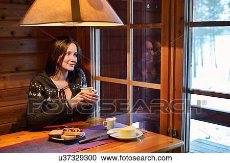 "Portrait of young woman drinking coffee and looking out of window, Posio, Lapland, Finland" View Large Photo Image Stock Image - "Portrait of young woman drinking coffee and looking out of window, Posio, Lapland, Finland". Fotosearch