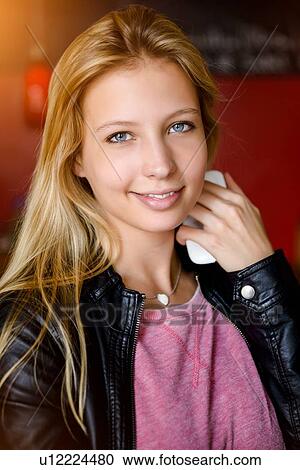 Portrait of young woman holding smartphone in cafe View Large Photo Image Stock Image - Portrait of young woman holding smartphone in cafe. Fotosearch