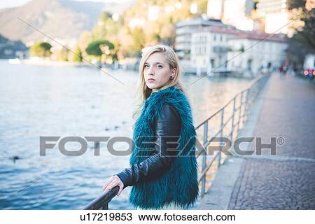 Stock Image - "Portrait of young woman holding railings at Lake Como, Como, Italy". Fotosearch