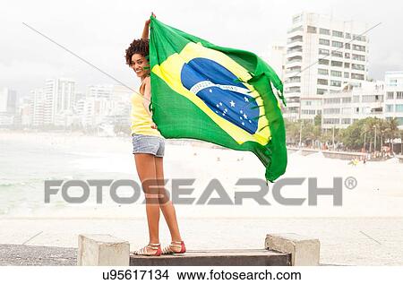 "Portrait of young woman holding up Brazilian flag on park bench, Ipanema beach, Rio De Janeiro, Brazil" View Large Photo Image Picture - "Portrait of young woman holding up Brazilian flag on park bench, Ipanema beach, Rio De Janeiro, Brazil". Fotosearch
