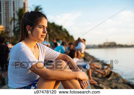 Stock Image - "Portrait of young woman looking out from waterfront, Manila, Philippines". Fotosearch