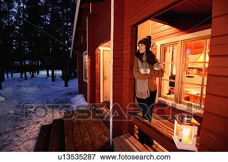 "Portrait of young woman looking out from cabin porch at night, Posio, Lapland, Finland" View Large Photo Image Stock Photo - "Portrait of young woman looking out from cabin porch at night, Posio, Lapland, Finland". Fotosearch