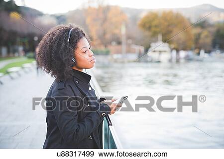 Stock Photo - "Portrait of young woman looking out from park at Lake Como, Italy". Fotosearch