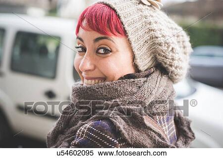 "Portrait of young woman looking over shoulder, smiling, wearing winter clothes" View Large Photo Image Stock Photography - "Portrait of young woman looking over shoulder, smiling, wearing winter clothes". Fotosearch