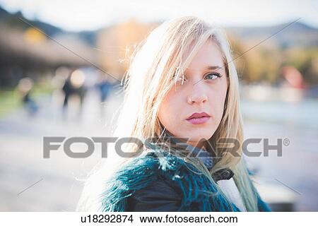 Portrait of young woman looking sideways in park View Large Photo Image Picture - Portrait of young woman looking sideways in park. Fotosearch