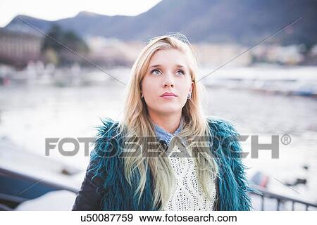 Stock Photo - "Portrait of young woman looking up at Lake Como, Como, Italy". Fotosearch
