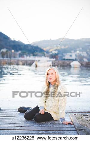 Stock Photo - "Portrait of young woman on lakeside pier, Lake Como, Italy". Fotosearch