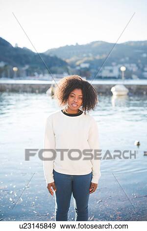 Stock Photo - "Portrait of young woman on lakeside, Lake Como, Italy". Fotosearch