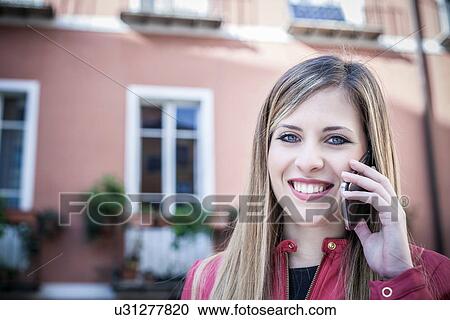 "Portrait of young woman on street talking on smartphone, Cagliari, Sardinia, Italy" View Large Photo Image Stock Image - "Portrait of young woman on street talking on smartphone, Cagliari, Sardinia, Italy". Fotosearch