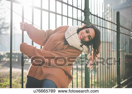 Portrait of young woman swinging from park railings View Large Photo Image Stock Photo - Portrait of young woman swinging from park railings. Fotosearch