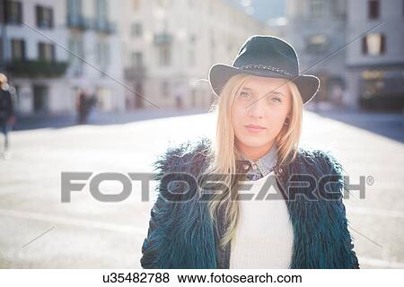 Portrait of young woman wearing fedora hat in town square View Large Photo Image Stock Photo - Portrait of young woman wearing fedora hat in town square. Fotosearch