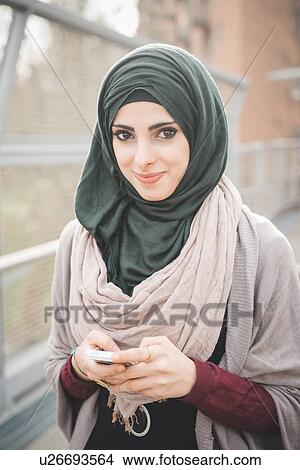 Portrait of young woman wearing hijab on footbridge View Large Photo Image Picture - Portrait of young woman wearing hijab on footbridge. Fotosearch