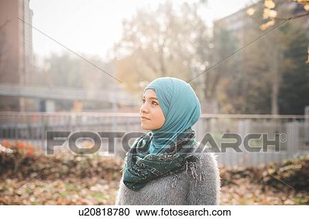 Portrait of young woman wearing hijab gazing in park View Large Photo Image Stock Image - Portrait of young woman wearing hijab gazing in park. Fotosearch