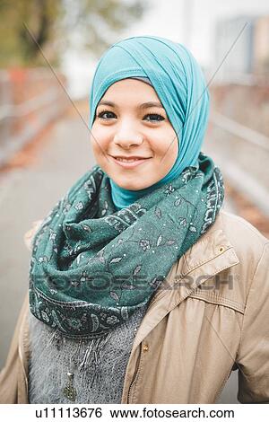 Portrait of young woman wearing turquoise hijab on park path View Large Photo Image Stock Photograph - Portrait of young woman wearing turquoise hijab on park path. Fotosearch
