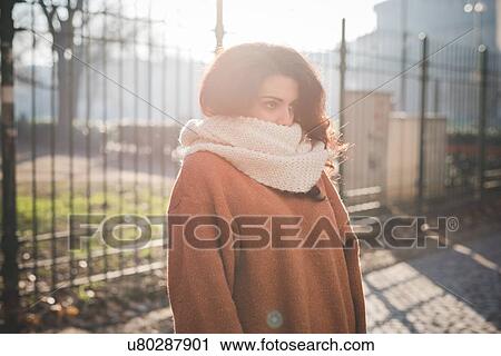 Portrait of young woman with scarf covering mouth in park View Large Photo Image Stock Image - Portrait of young woman with scarf covering mouth in park. Fotosearch