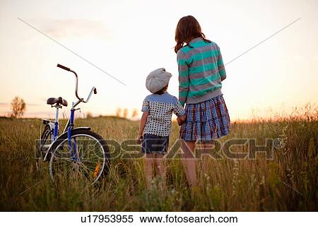 "Rear view of boy and mother holding hands in field at sunset, Sarsy village, Sverdlovsk Region, Russia" View Large Photo Image Stock Photography - "Rear view of boy and mother holding hands in field at sunset, Sarsy village, Sverdlovsk Region, Russia". Fotosearch
