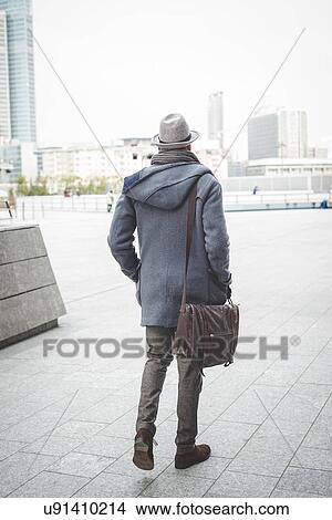 Picture - Rear view of businessman walking outside office buildings. Fotosearch