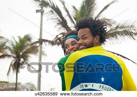 "Rear view of couple wrapped in Brazilian flag on Ipanema beach, Rio De Janeiro, Brazil" View Large Photo Image Stock Photo - "Rear view of couple wrapped in Brazilian flag on Ipanema beach, Rio De Janeiro, Brazil". Fotosearch