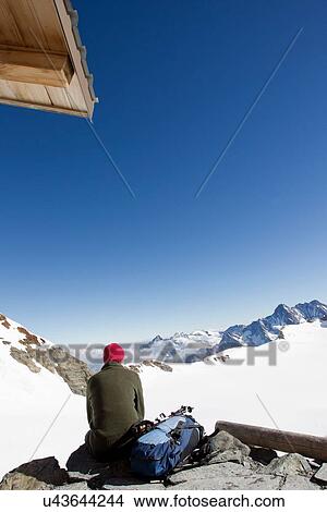 "Rear view of male hiker looking out at landscape from viewing platform, Jungfrauchjoch, Grindelwald, Switzerland" View Large Photo Image Picture - "Rear view of male hiker looking out at landscape from viewing platform, Jungfrauchjoch, Grindelwald, Switzerland". Fotosearch