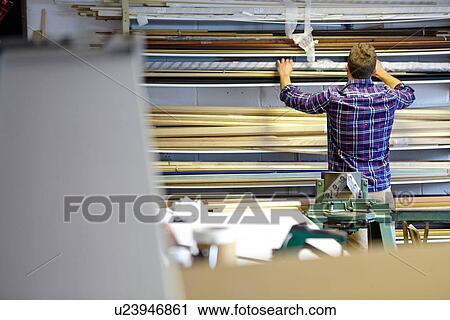 Rear view of man searching stockroom shelves in picture framers workshop View Large Photo Image Stock Image - Rear view of man searching stockroom shelves in picture framers workshop. Fotosearch