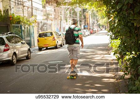 "Rear view of mature man skateboarding on street, Rio De Janeiro, Brazil" View Large Photo Image Stock Photo - "Rear view of mature man skateboarding on street, Rio De Janeiro, Brazil". Fotosearch