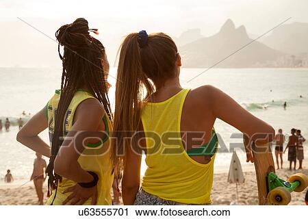 "Rear view of two young women looking out over Ipanema beach, Rio De Janeiro, Brazil" View Large Photo Image Stock Image - "Rear view of two young women looking out over Ipanema beach, Rio De Janeiro, Brazil". Fotosearch