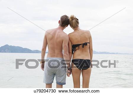 "Rear view of young couple holding hands on beach, Kradan, Thailand" View Large Photo Image Stock Image - "Rear view of young couple holding hands on beach, Kradan, Thailand". Fotosearch