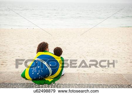 "Rear view of young mother and son wrapped in Brazilian flag on Ipanema beach, Rio De Janeiro, Brazil" View Large Photo Image Stock Photo - "Rear view of young mother and son wrapped in Brazilian flag on Ipanema beach, Rio De Janeiro, Brazil". Fotosearch