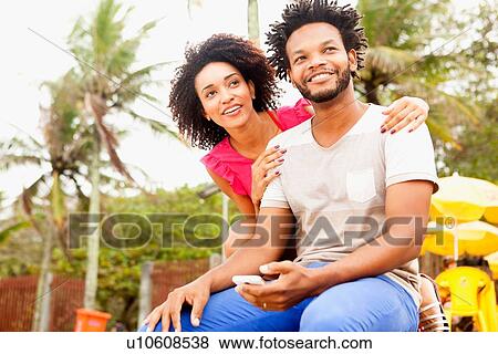 Stock Photo - "Romantic couple sitting, Ipanema beach, Rio De Janeiro, Brazil". Fotosearch