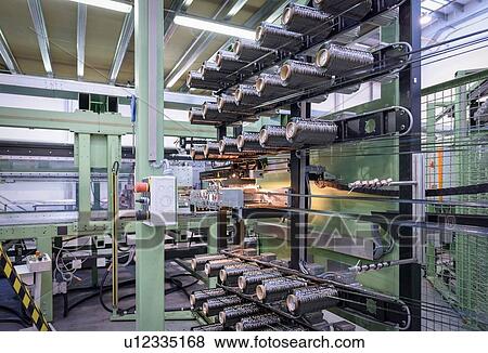 Stock Photo - Rows of carbon fibre on loom in carbon fibre factory. Fotosearch