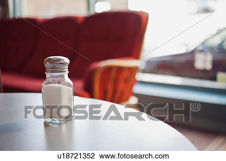 Stock Image - Salt shaker on table. Fotosearch