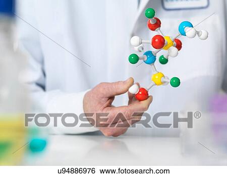 Scientist holding a molecular model of a chemical formula View Large Photo Image Stock Photograph - Scientist holding a molecular model of a chemical formula. Fotosearch