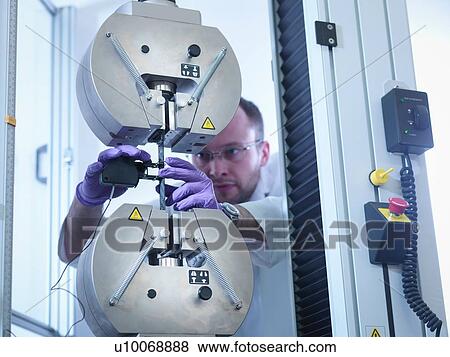 Stock Photo - Scientist tests tensile strength of carbon fibre in carbon fibre laboratory. Fotosearch