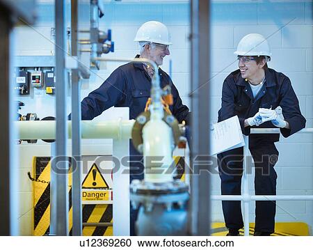 Senior and apprentice engineers talking in power station View Large Photo Image Stock Image - Senior and apprentice engineers talking in power station. Fotosearch