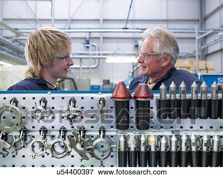 Senior engineer instructing apprentice in factory View Large Photo Image Stock Photo - Senior engineer instructing apprentice in factory. Fotosearch