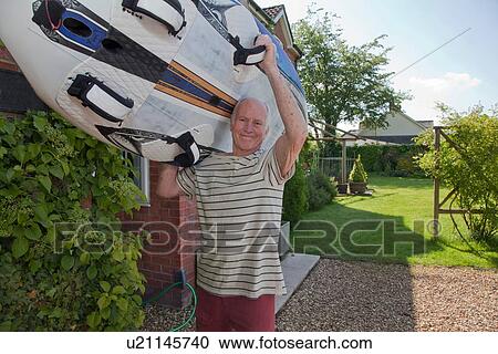 Senior man carrying surfboard View Large Photo Image Stock Image - Senior man carrying surfboard. Fotosearch