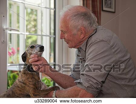 Senior man stroking pet dog View Large Photo Image Picture - Senior man stroking pet dog. Fotosearch
