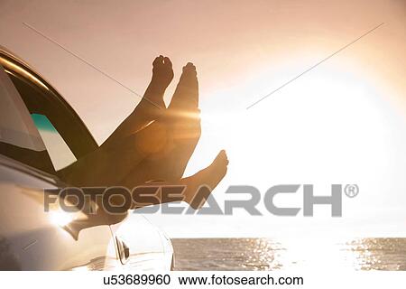 "Silhouetted feet out of car window at sunset, Miami, Florida, USA" View Large Photo Image Stock Image - "Silhouetted feet out of car window at sunset, Miami, Florida, USA". Fotosearch