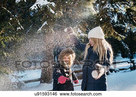 Stock Photograph - Sisters playing in the snow. Fotosearch