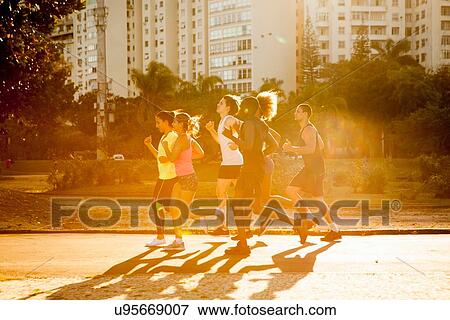 Stock Photo - Six adult friends doing training run in park. Fotosearch