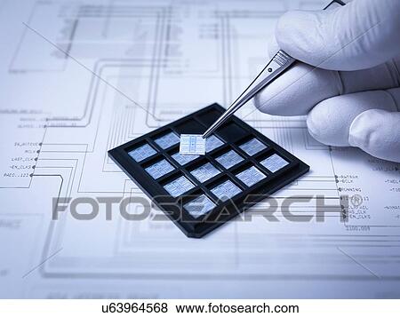 "Small electronic chips held in tweezers in laboratory, close up" View Large Photo Image Stock Photo - "Small electronic chips held in tweezers in laboratory, close up". Fotosearch