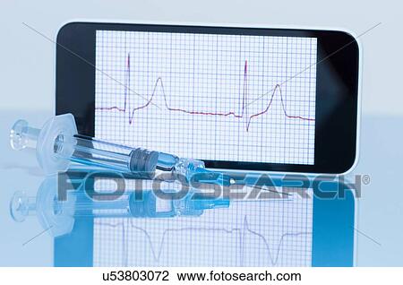 Stock Image - "Smart phone displaying an electrocardiogram, disposable syringe in foreground". Fotosearch