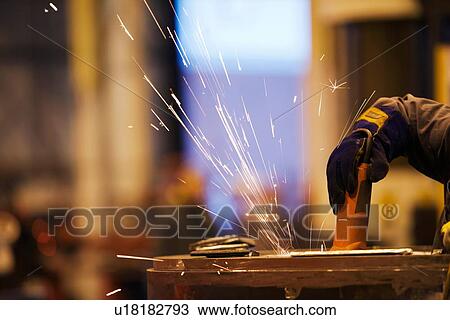 Sparks from worker using grinder in factory View Large Photo Image Stock Image - Sparks from worker using grinder in factory. Fotosearch