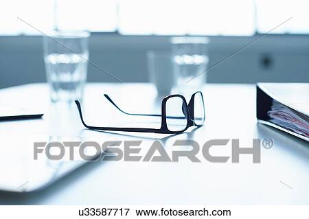 Stock Photo - Spectacles and digital tablet on conference table. Fotosearch