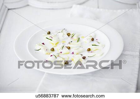 Stock Photo - "Still life of carpaccio of raw fish, capers and herbs". Fotosearch