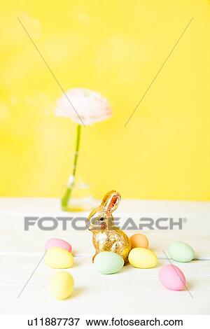 Stock Photo - "Still life of cut flower in bottle, Easter eggs and bunny". Fotosearch