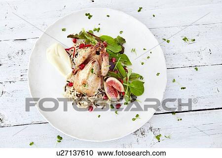Stock Image - Still life of plate with roasted wildfowl and figs. Fotosearch
