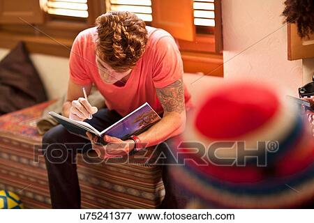 Stock Photo - Student studying in living room. Fotosearch