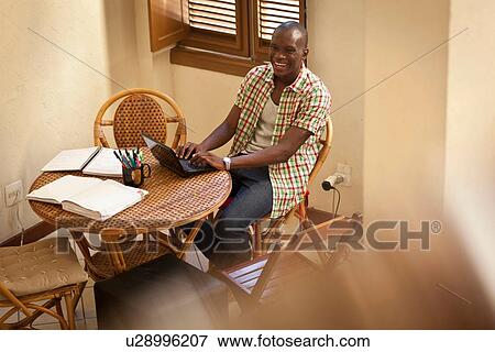 Student using laptop at dining table View Large Photo Image Stock Photo - Student using laptop at dining table. Fotosearch