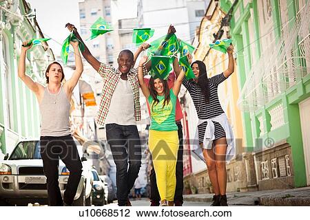 Stock Image - "Students celebrating with Brazilian flags in the street, Rio de Janeiro, Brazil". Fotosearch